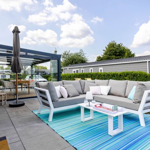 Außenansicht mit großem Sonnenschirm, Sitzlounge und Wintergarten
