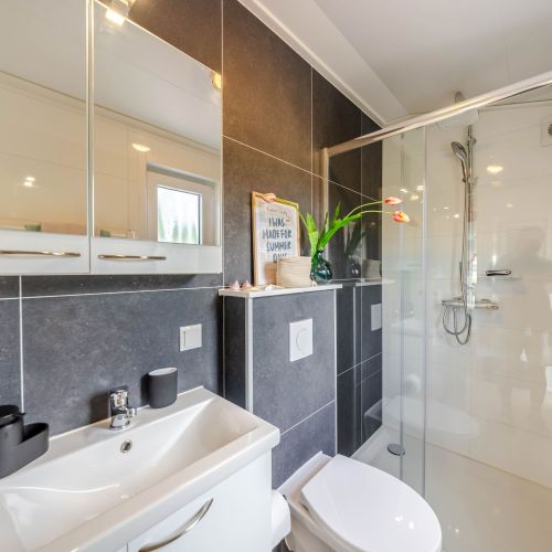 Modernes Bad mit Waschtisch und Spiegelschrank, bodentiefer großer Dusche, Fenster,Fliuegengitter